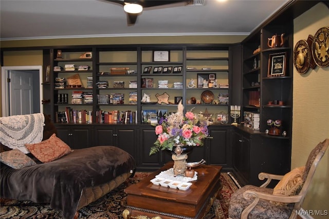 living area featuring ceiling fan and ornamental molding