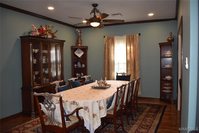 dining area with ceiling fan, crown molding, and dark wood-type flooring