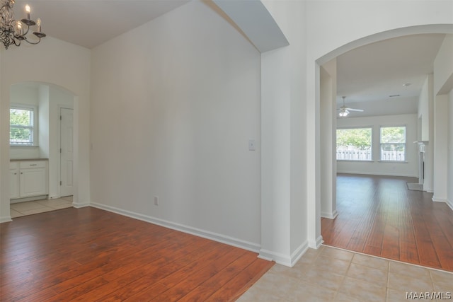 hall featuring an inviting chandelier and light tile floors