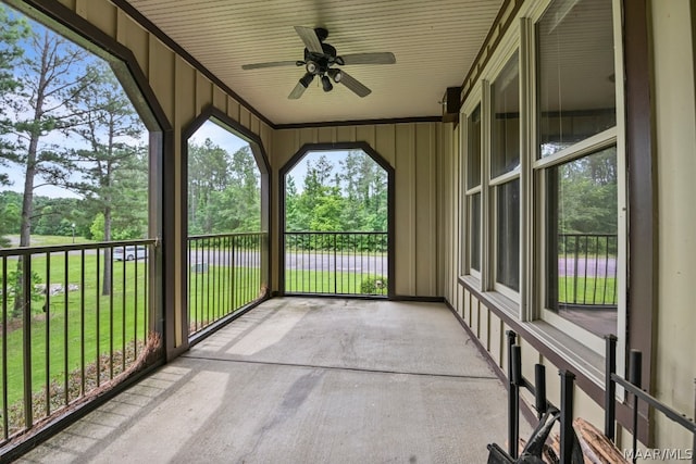 unfurnished sunroom featuring ceiling fan