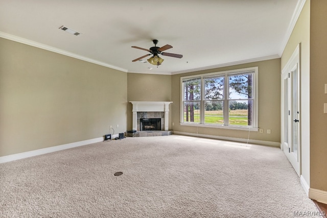 unfurnished living room featuring ceiling fan, a tile fireplace, crown molding, and carpet flooring