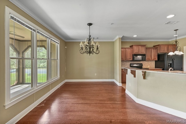 kitchen featuring backsplash, dark wood-type flooring, a kitchen bar, and black appliances