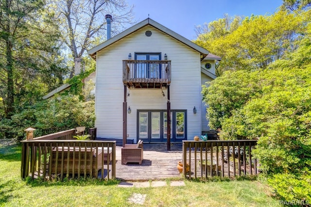 back of property featuring a balcony and a yard