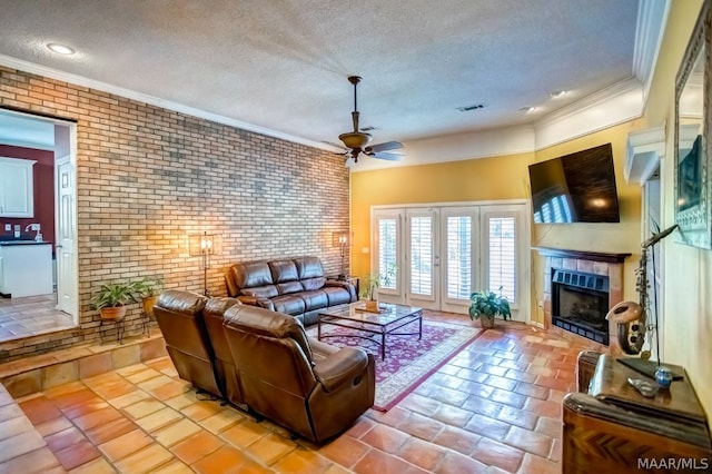 living room with a tile fireplace, a textured ceiling, ceiling fan, and light tile patterned floors