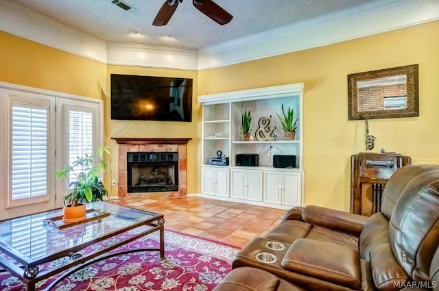 living room featuring a fireplace, tile patterned floors, ornamental molding, and ceiling fan