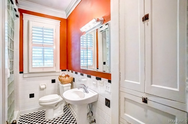 bathroom with tile patterned flooring, crown molding, tasteful backsplash, toilet, and tile walls