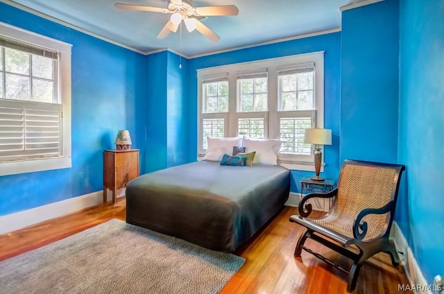 bedroom with multiple windows, ceiling fan, and light hardwood / wood-style floors