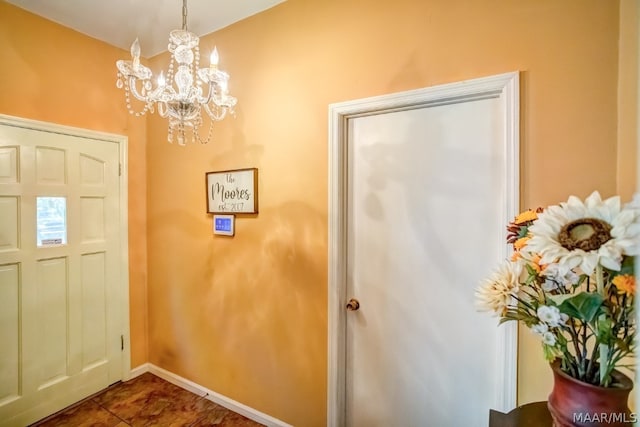 tiled entrance foyer featuring a notable chandelier