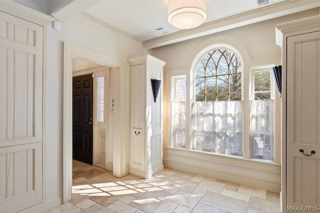 interior space with a wealth of natural light, visible vents, and stone tile flooring