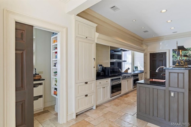 kitchen with visible vents, ornamental molding, a sink, and oven