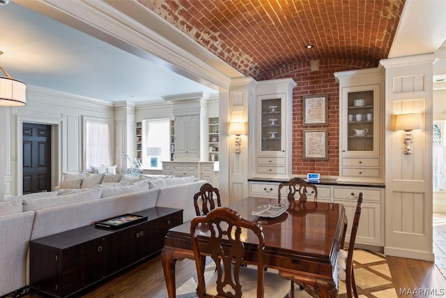 dining room featuring brick ceiling, light wood-type flooring, and lofted ceiling