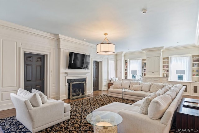 living room featuring dark wood-type flooring, ornamental molding, and a premium fireplace