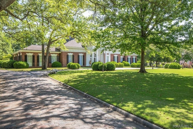 view of front of property featuring brick siding and a front lawn