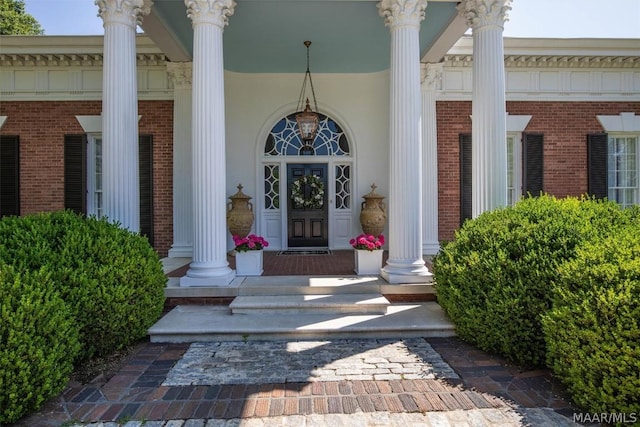 view of exterior entry with brick siding