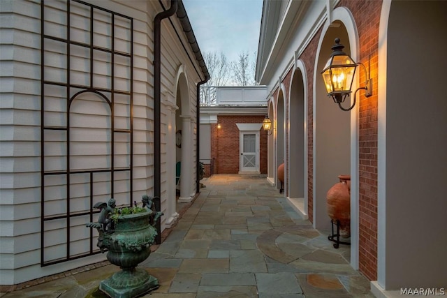 view of property exterior with a patio and brick siding