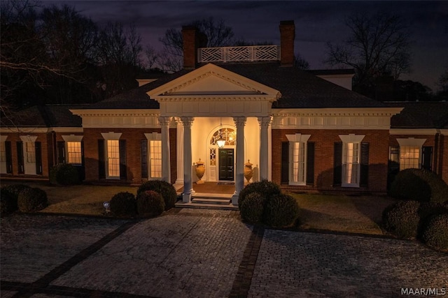 neoclassical home featuring brick siding