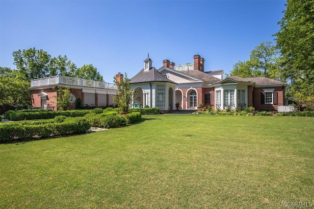 view of front of home featuring brick siding and a front yard