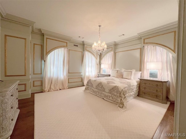 bedroom featuring visible vents, ornamental molding, a decorative wall, and a notable chandelier