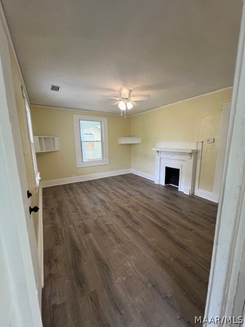 unfurnished living room featuring ceiling fan, dark hardwood / wood-style flooring, and crown molding