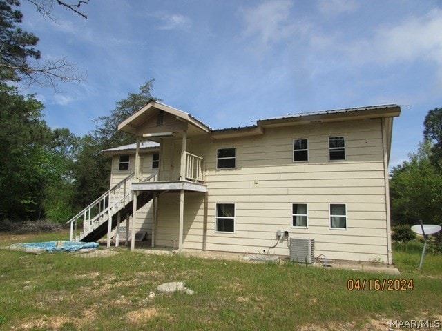 back of house featuring central AC and a yard