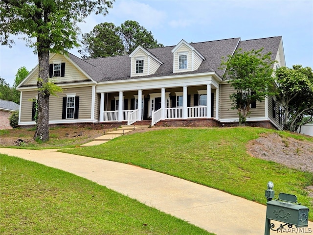 cape cod-style house featuring a front yard and covered porch