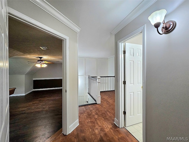 hall featuring ornamental molding, dark wood-type flooring, and vaulted ceiling