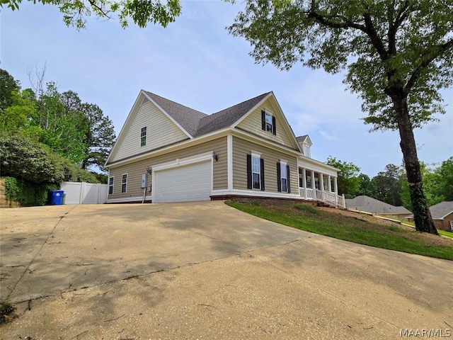 view of home's exterior featuring a garage and covered porch