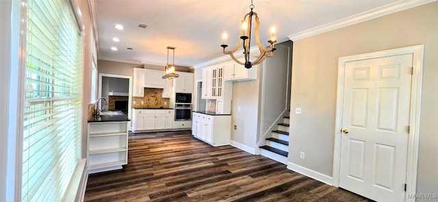 kitchen featuring hanging light fixtures, oven, white cabinetry, a notable chandelier, and dark wood-type flooring