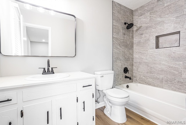 full bathroom with vanity, tiled shower / bath combo, wood-type flooring, and toilet