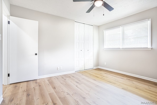 unfurnished bedroom with a closet, ceiling fan, and light wood-type flooring