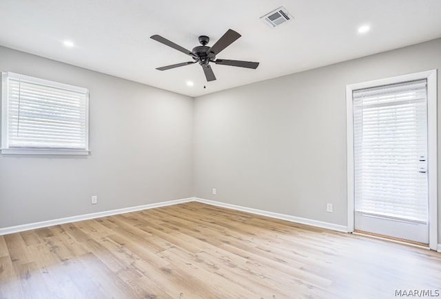 spare room with light hardwood / wood-style floors, a healthy amount of sunlight, and ceiling fan