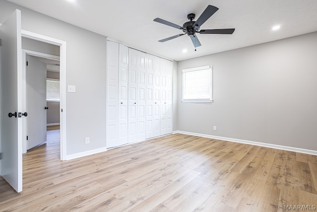 unfurnished bedroom featuring light hardwood / wood-style floors, a closet, and ceiling fan