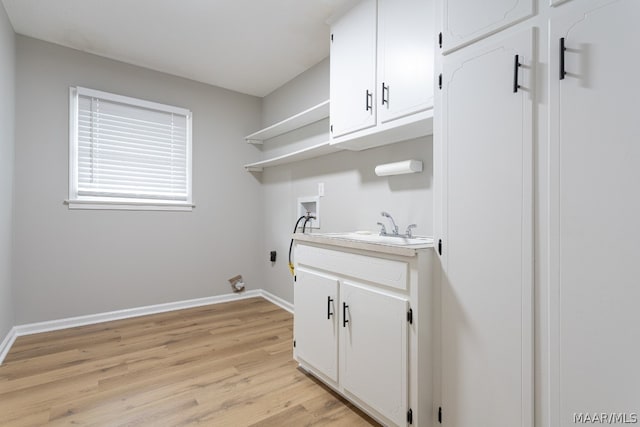 clothes washing area with hookup for a washing machine, cabinets, sink, and light wood-type flooring