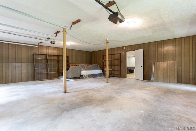 garage with wood walls and a garage door opener