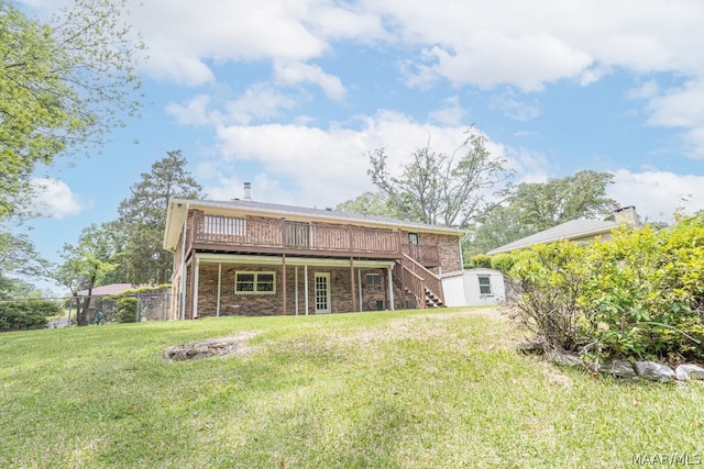 back of house featuring a yard, a wooden deck, and an outbuilding