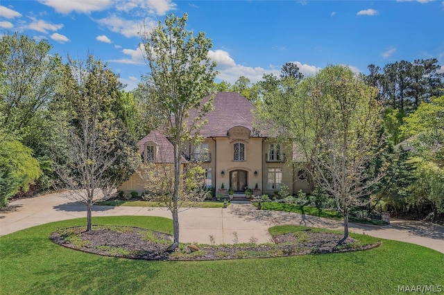 french country style house with a front lawn