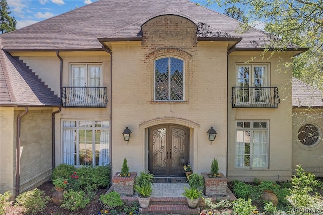 french country home featuring french doors and a balcony