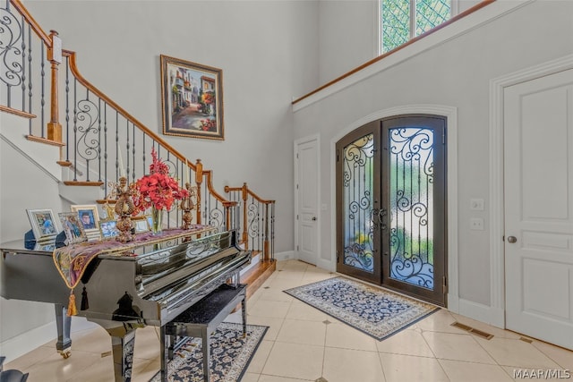 tiled foyer with french doors and a high ceiling