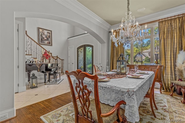 dining room featuring ornamental molding, light tile flooring, a wealth of natural light, and an inviting chandelier