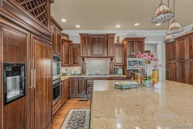 kitchen with decorative light fixtures, stainless steel appliances, tasteful backsplash, light wood-type flooring, and ornamental molding