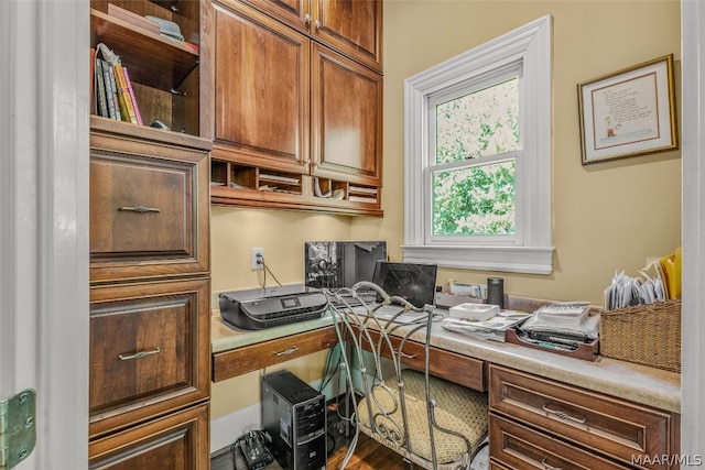 home office featuring wood-type flooring and built in desk