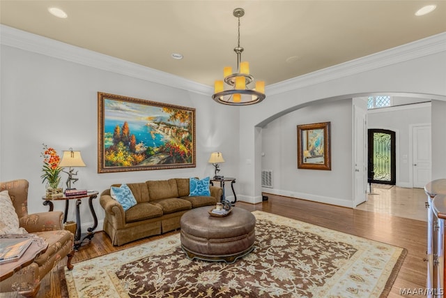 living room featuring hardwood / wood-style floors, a notable chandelier, and ornamental molding