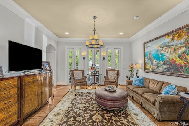 living room featuring light hardwood / wood-style flooring, crown molding, and an inviting chandelier