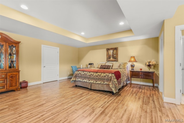 bedroom featuring hardwood / wood-style flooring and a tray ceiling