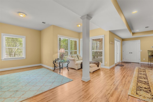 interior space featuring ornate columns and light hardwood / wood-style floors