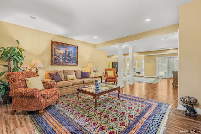 living room featuring wood-type flooring and decorative columns