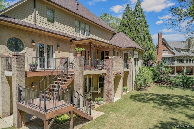 rear view of property featuring a wooden deck and a yard