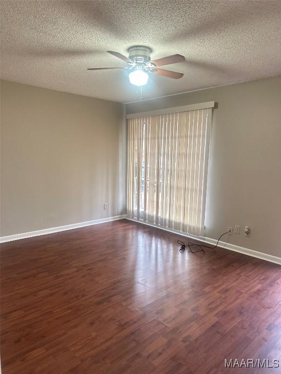 unfurnished room featuring ceiling fan, dark hardwood / wood-style floors, and a textured ceiling