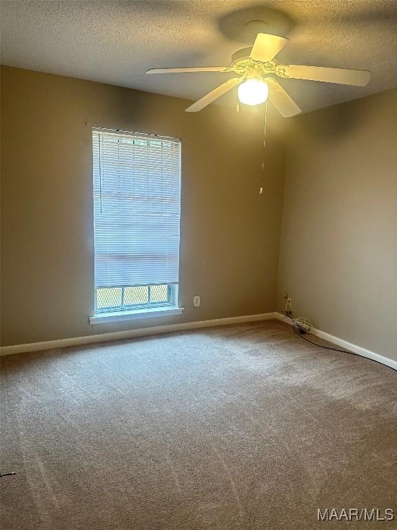 unfurnished room with ceiling fan, carpet floors, and a textured ceiling