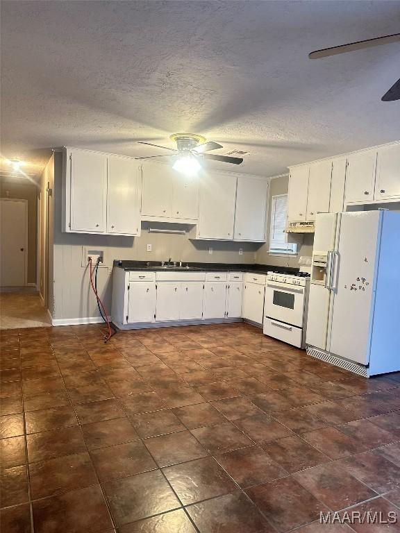 kitchen with a textured ceiling, white cabinets, and white appliances